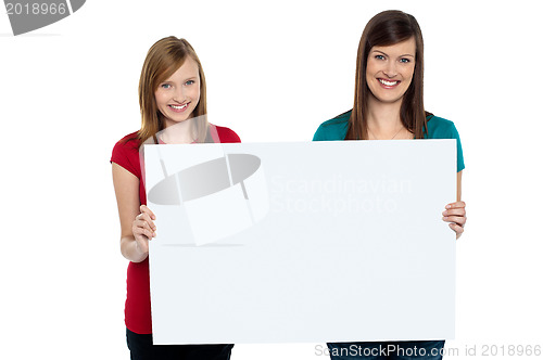 Image of Gorgeous women presenting blank ad board
