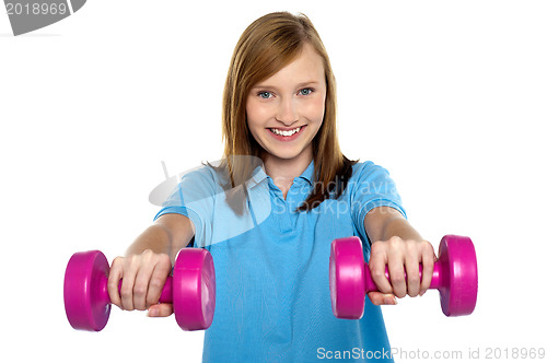 Image of Adorable teen holding dumbbells in her outstretched arms