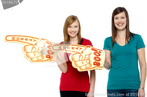 Image of Cheerful fans pointing the big foam hand sideways