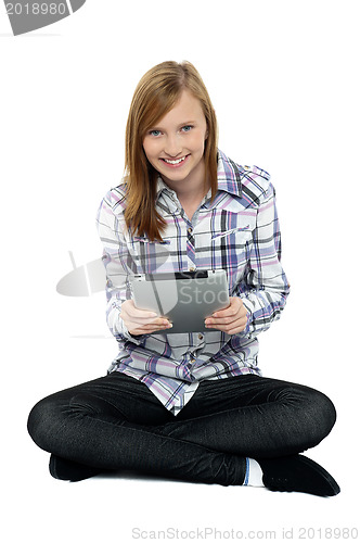 Image of Smartly dressed teenager surfing on tablet pc