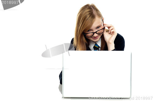 Image of Girl adjusting her spectacles while working on laptop