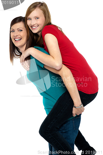 Image of Happy mother giving piggyback ride to her daughter