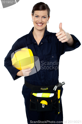 Image of Woman in builder uniform showing thumbs up