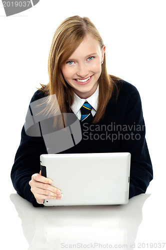 Image of Pretty schoolgirl holding newly launched tablet pc