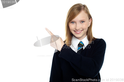 Image of Calm and relaxed teen girl pointing sideways