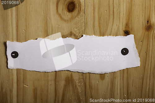 Image of White paper attached by rusty push pins