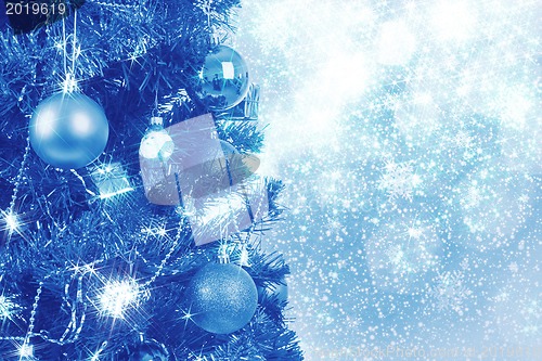 Image of blue christmas background with balls on tree 