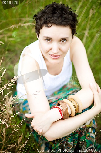Image of young cute girl resting on fresh spring grass 
