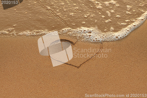 Image of Heart drawing in the sand on the morning beach