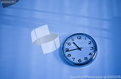 Image of blue clock on a blue wall