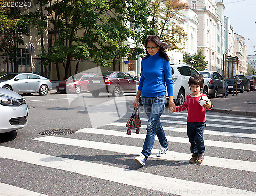Image of Mother and son are on a pedestrian crossing in the city