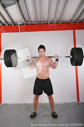 Image of Man with dumbbell weight training equipment on sport gym