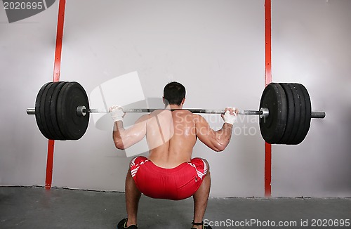 Image of The concept of power and determination of a man lifting a weight