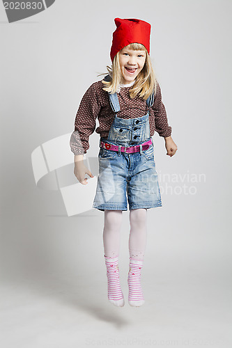 Image of Happy young girl wearing Christmas elf hat jumping