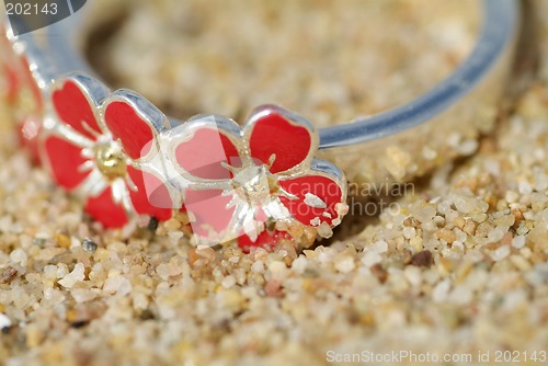 Image of Detail of silver ring in the sand