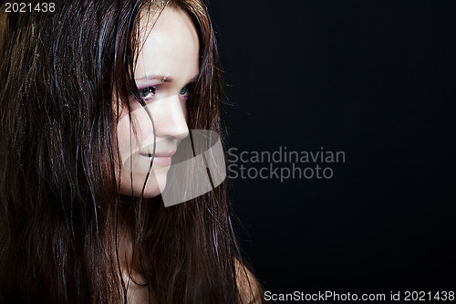 Image of beautiful girl with long wet hair on a black background