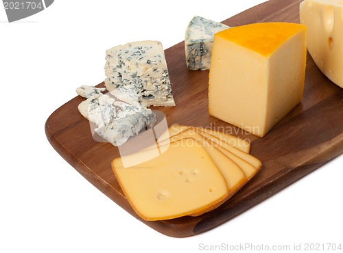 Image of Different types of cheese on wooden kitchen board