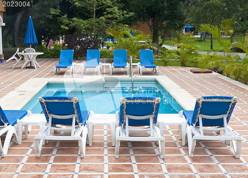 Image of Beautiful pool and patio in tropical setting 