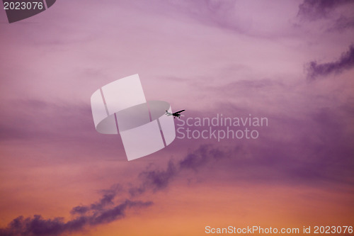 Image of airplane flying at sunset