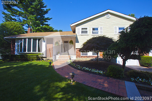 Image of Luxury family house with landscaping on the front and blue sky o