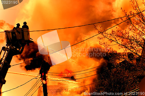 Image of a huge fire with firefighters in action 