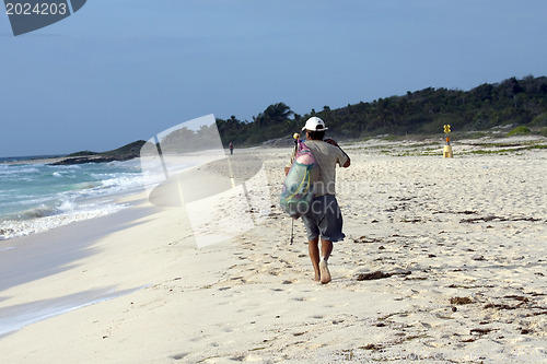 Image of Man walking on the beach in the morning.