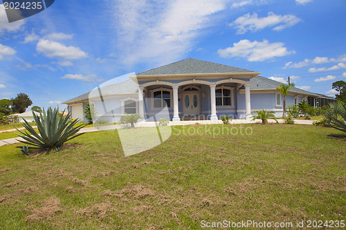 Image of Luxury family house with landscaping on the front and blue sky o