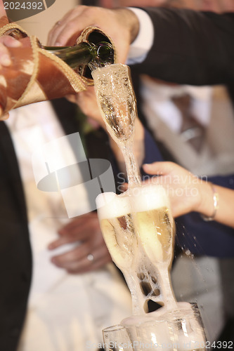 Image of Pouring champagne into a glass on a wedding celebration