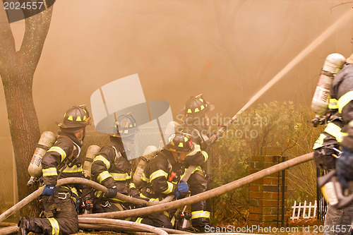 Image of Firemen at work putting out a house fire