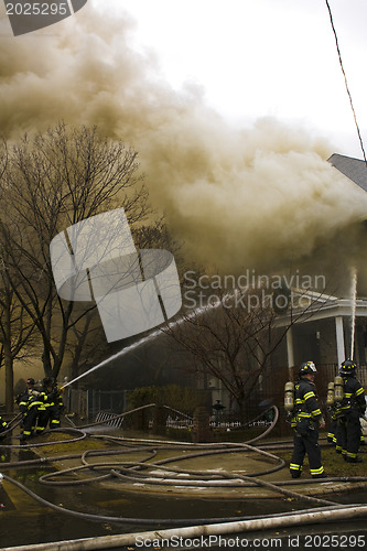 Image of Firemen at work putting out a house fire