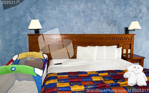 Image of King size bed with crib in room