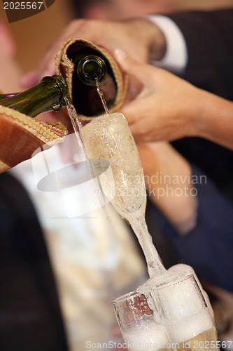 Image of Pouring champagne into a glass on a wedding celebration