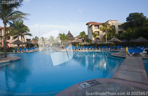 Image of Beautiful pool and patio in tropical setting 