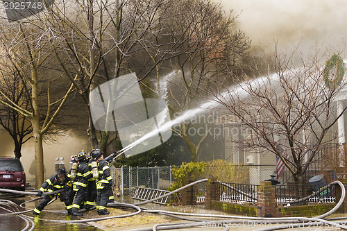 Image of Firemen at work putting out a house fire