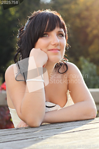 Image of Girl in the wedding dress sitting on the bench