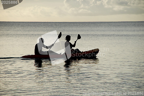 Image of Man and woman silhouetted at sea in a kayak