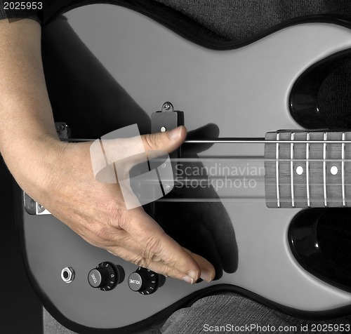 Image of bass guitar and hand