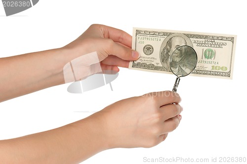 Image of Hand with magnifying glass and dollars