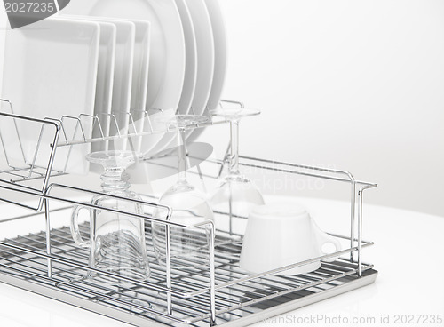 Image of Dishes and glasses drying on metal dish rack