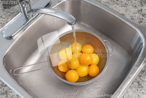 Image of Washing yellow tomatoes