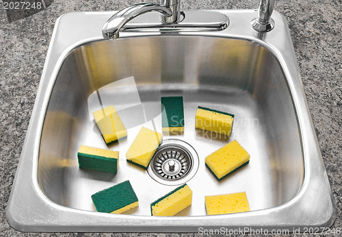 Image of Lots of yellow sponges in a clean kitchen sink