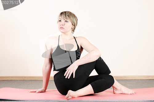 Image of young woman doing yoga exercises