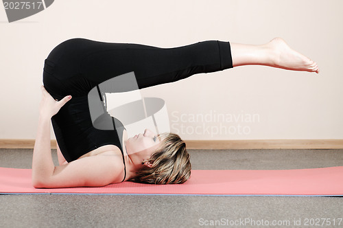 Image of young woman doing yoga exercises