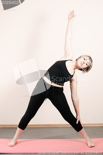 Image of young woman doing yoga exercises