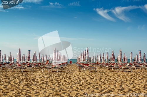 Image of withdrawn umbrellas and sunlongers on the sandy beach