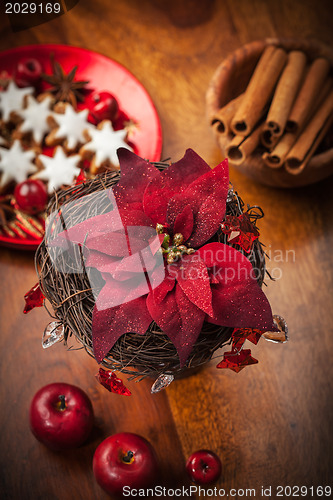 Image of Christmas flower with decoration on wooden table