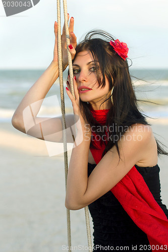 Image of sexy young woman sitting on a swing