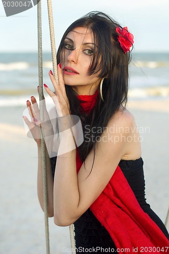 Image of nice young woman sitting on a swing