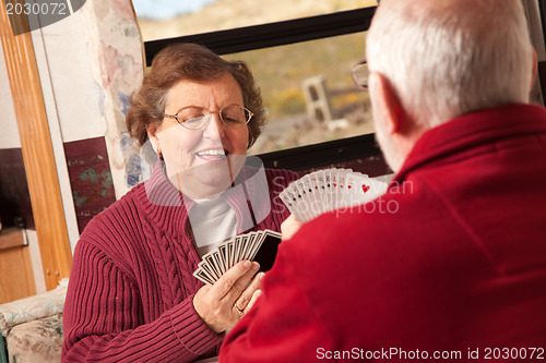 Image of Happy Senior Adult Couple Playing Cards in Their Trailer RV