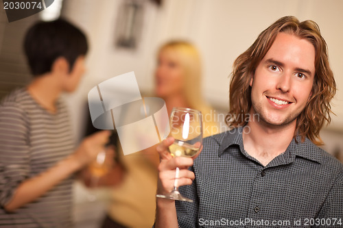 Image of Smiling Young Man with Glass of Wine Socializing